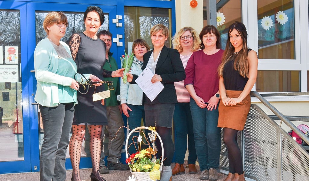 Schulreferentin Kerstin Orlick (2.v.l.) übergibt an Daniela Noth die Ernennung zur Schulleiterin. Das Kollegium gratuliert der neuen Leiterin mit einem Blumenkorb und symbolischem Schulschlüssel.