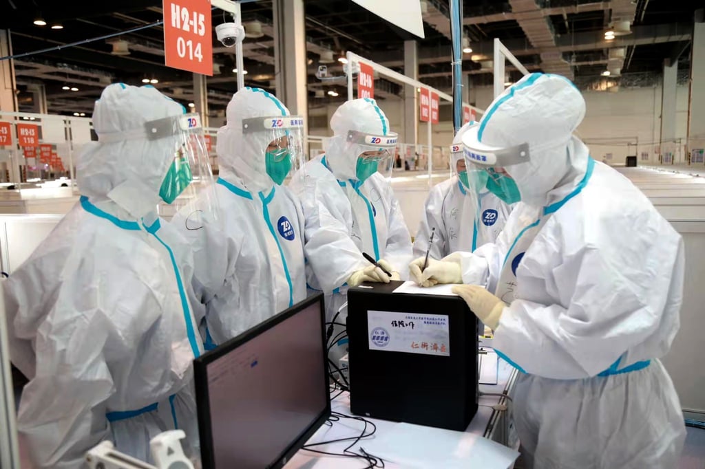 Komplett in Schutzanzügen: Mitarbeiter in einer ausgewiesenen Quarantäneeinrichtung in Shanghai.