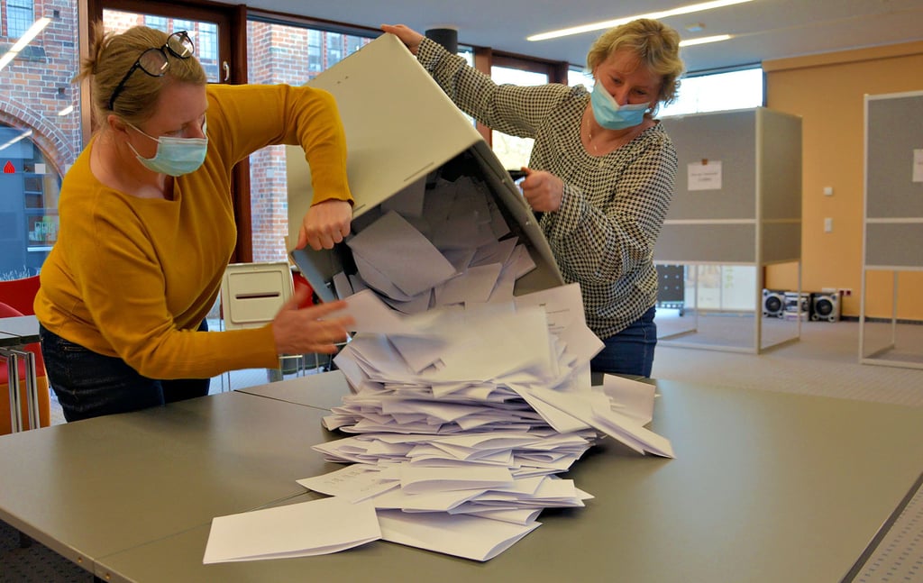 Simone Muleit (links) und Camilla Sedlick übernahmen es im Wahllokal Stadtbibliothek, die Urne zu öffnen und die Stimmzettel für die Auszählung auf die Tische zu schütten.