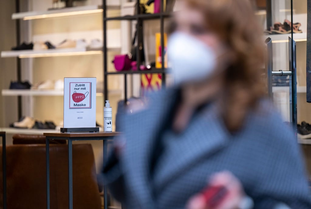 Ein Schild am Eingang eines Schuh-Geschäfts weist auf die Pflicht zum Tragen einer FFP2-Maske hin.