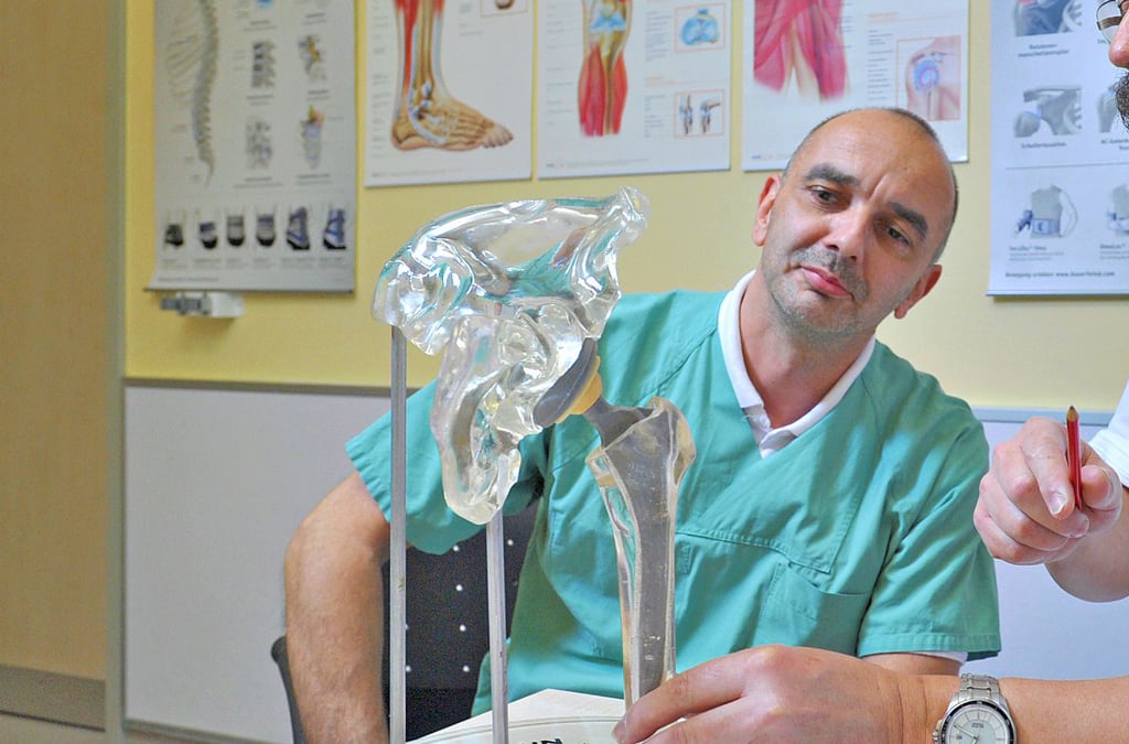 Dr. med. Ralf Schräpler (l.) ist Leiter des Endoprothetikzentrums. Hier bespricht er am Modell eines Hüftgelenks Operationsmöglichkeiten.