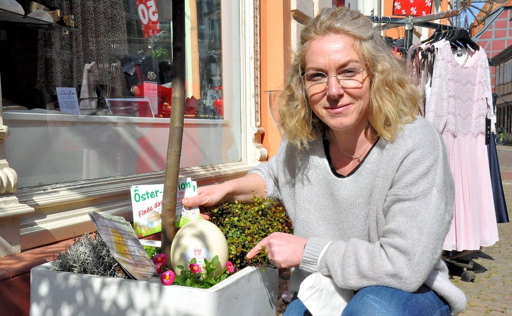 Nancy Kämpfer probierte schon einmal aus, wo sich das Straußenei vor dem Geschäft an der Burgstraße in Salzwedel am besten verstecken lässt.