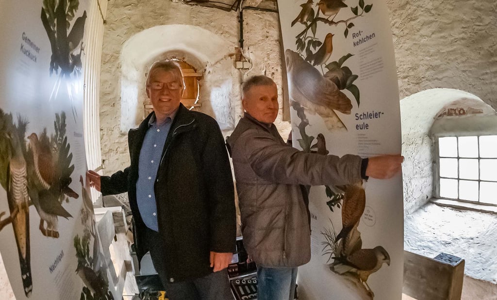 Zangenbergs Ortsbürgermeister Bernd Jäger (l.) und Rainer Helms an Schaubannern, die zur Ausstellung „Vögel der Elsteraue“ gehören.