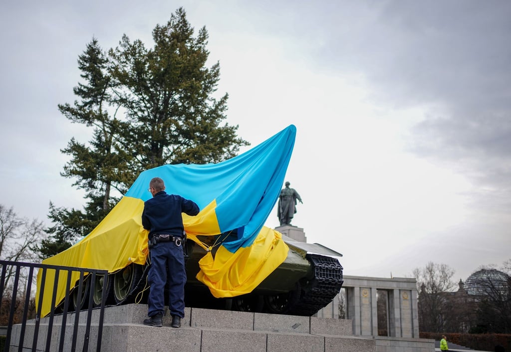 Polizeibeamte entfernen die Flagge der Ukraine von einem historischen Panzer am Sowjetischen Ehrenmal an der Straße des 17. Juni.