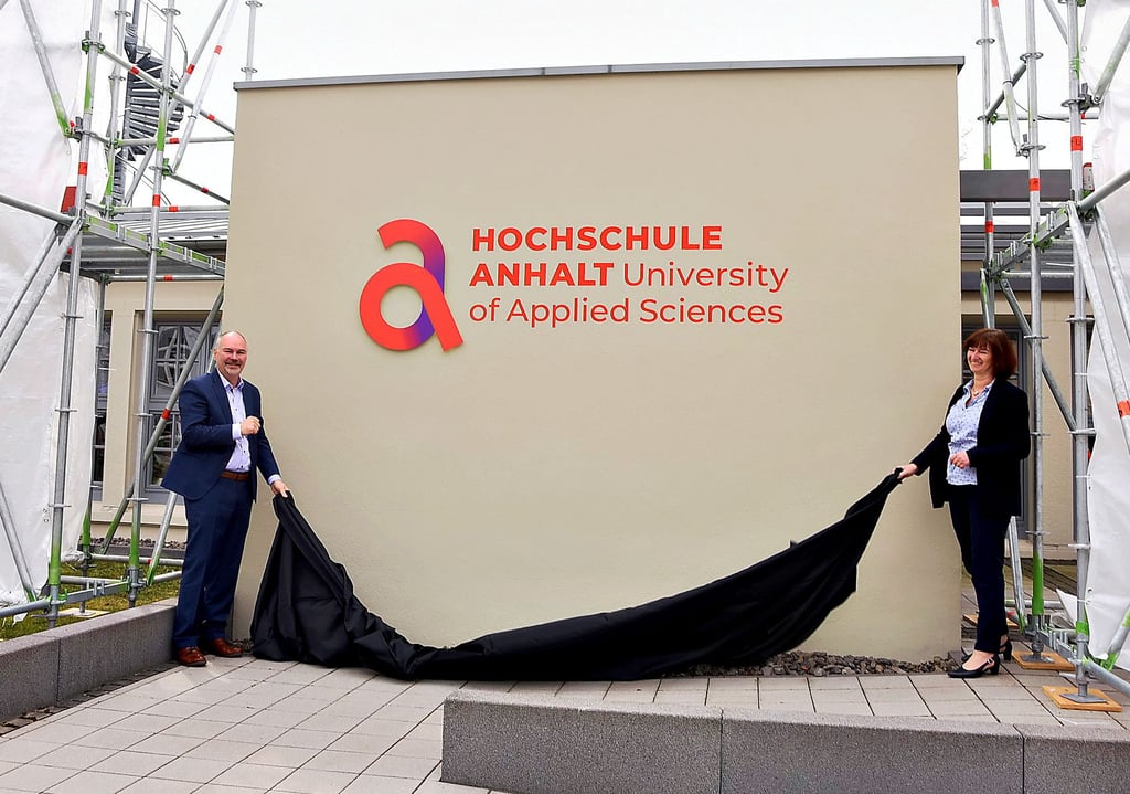 Präsident Jörg Bagdahn und Verwaltungschefin Sabine Thalmann enthüllen das neue Hochschul-Logo.