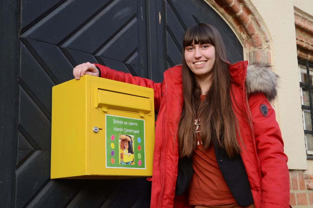 Maxima Kuhn, Auszubildende der Verwaltung, am Osterhasenbriefkasten. Dieser hängt an der Rathauskellertür gegenüber dem Brunnen.