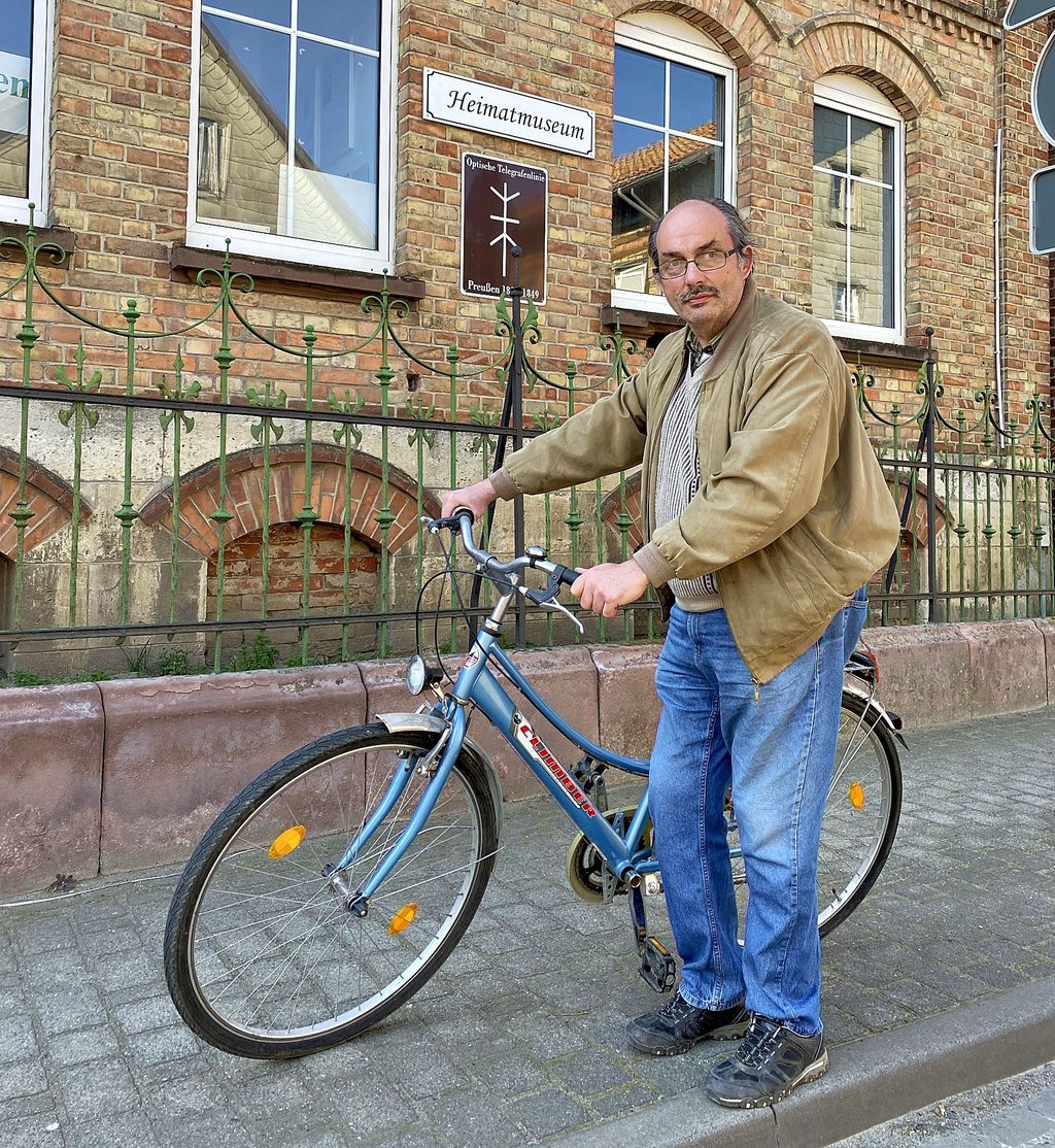 Museumschef Uwe Krebs macht es vor – und fährt mit dem Fahhrad ins Museum. Dieses liegt am Telegraphenradweg, der den Verlauf der Telegraphen-Linie von Berlin nach Koblenz nachvollzieht.