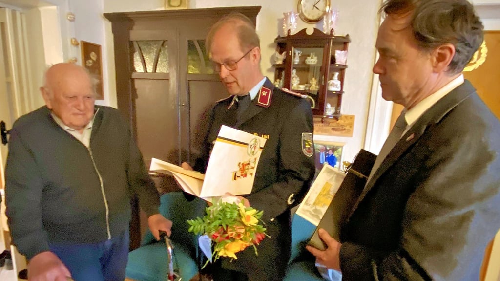 Naundorfs Wehrleiter Klaus Bolze gratuliert Erhard Schlüter mit einer Ehrenurkunde zur 80-jährigen Mitgliedschaft in der Feuerwehr. Auch Jessens Bürgermeister Michael Jahn wünscht ihm aus diesem Anlass alles Gute.