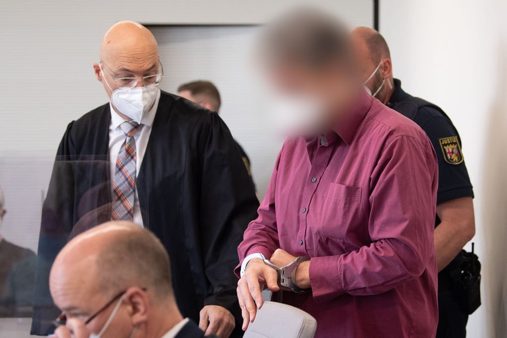 Der Angeklagte wird in Handschellen in den Gerichtssaal gebracht.