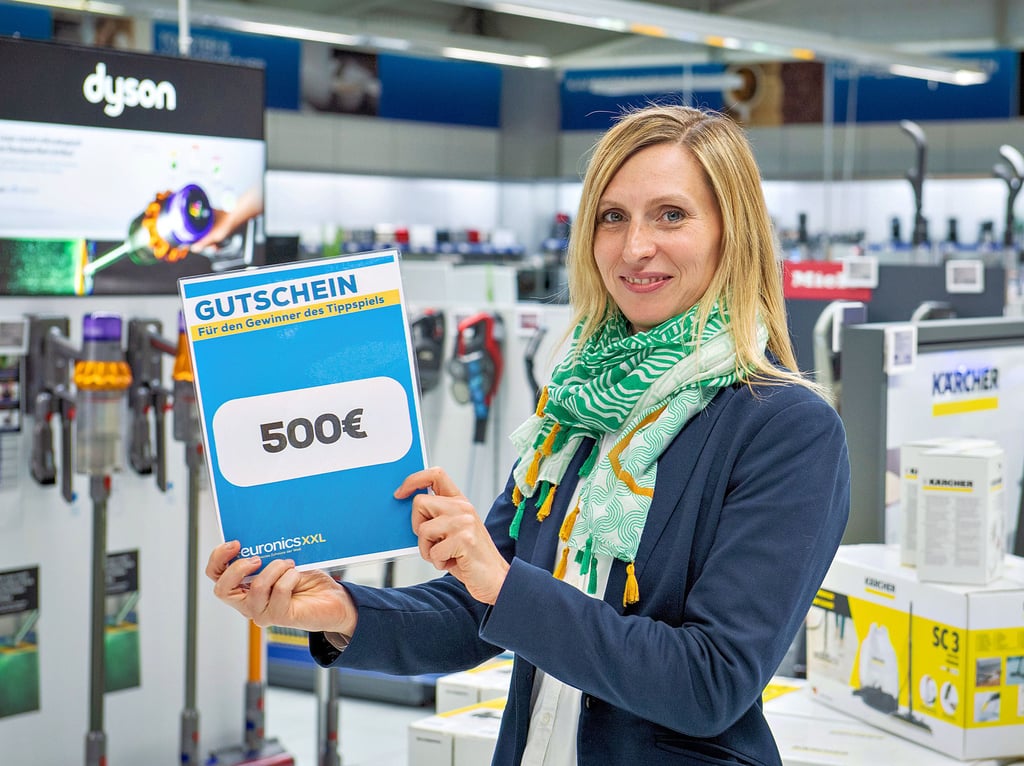 Die Geschäftsführerin von Euronics XXL in Naumburg, Marlene Raddei, präsentiert den Hauptpreis für den Gesamtsieg im neuen regionalen Fußball-Tippspiel von Tageblatt/MZ: einen Gutschein im Wert von 500 Euro.