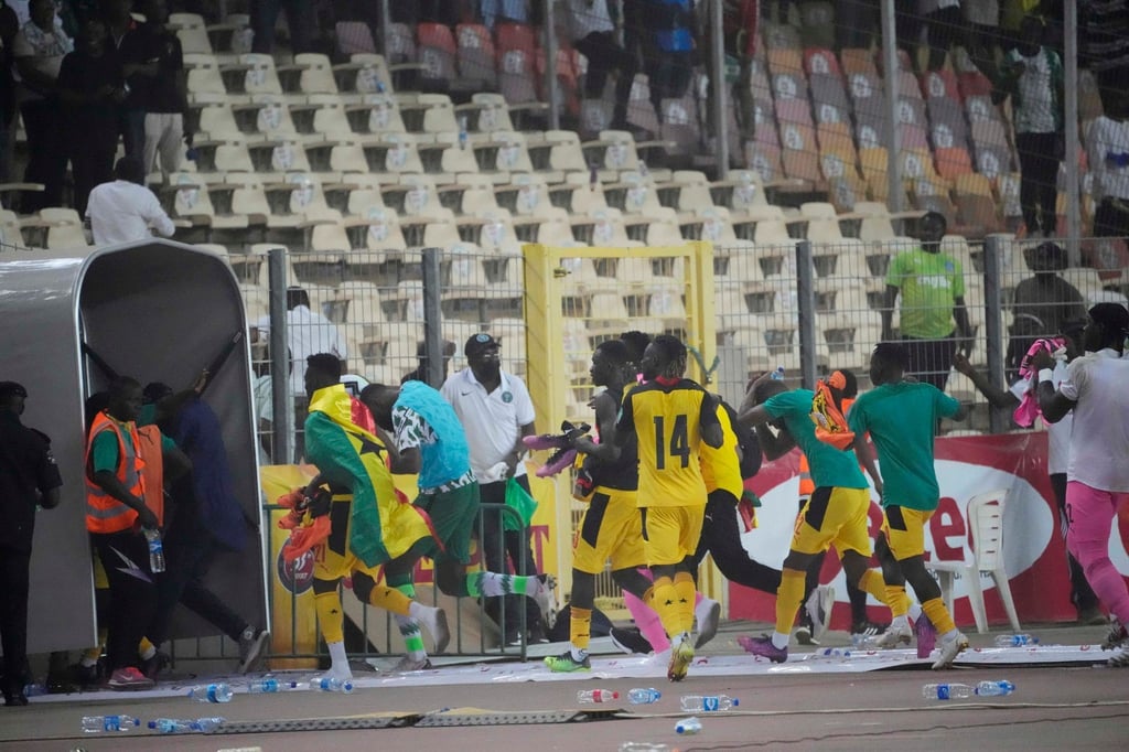 Ghanas Spieler rennen bringen sich nach dem Spiel in Abuja in Sicherheit.