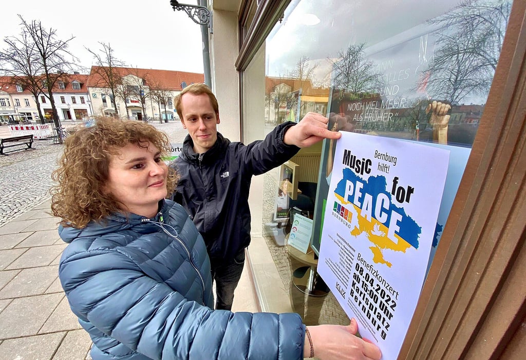 Kulturratsmitarbeiterin Julia Arlt und Veranstaltungstechniker Eric Klix hängen Plakate auf.