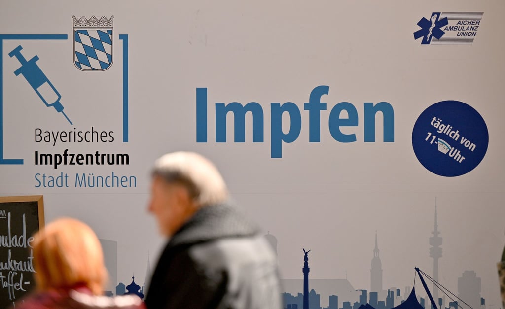 Passanten gehen in der Münchner Innenstadt an einem Impfzentrum vorbei, das im Rathaus untergebracht ist.