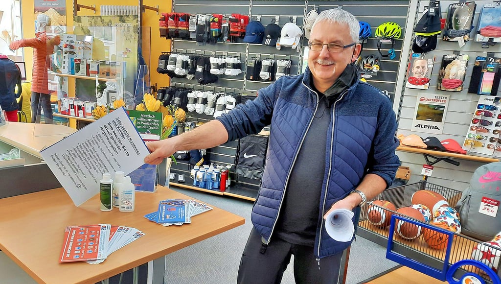 Rudolf Tischer, Inhaber des Intersport-Geschäfts in der Weißenfelser Jüdenstraße, räumt schon einmal das Hinweisschild ab.
