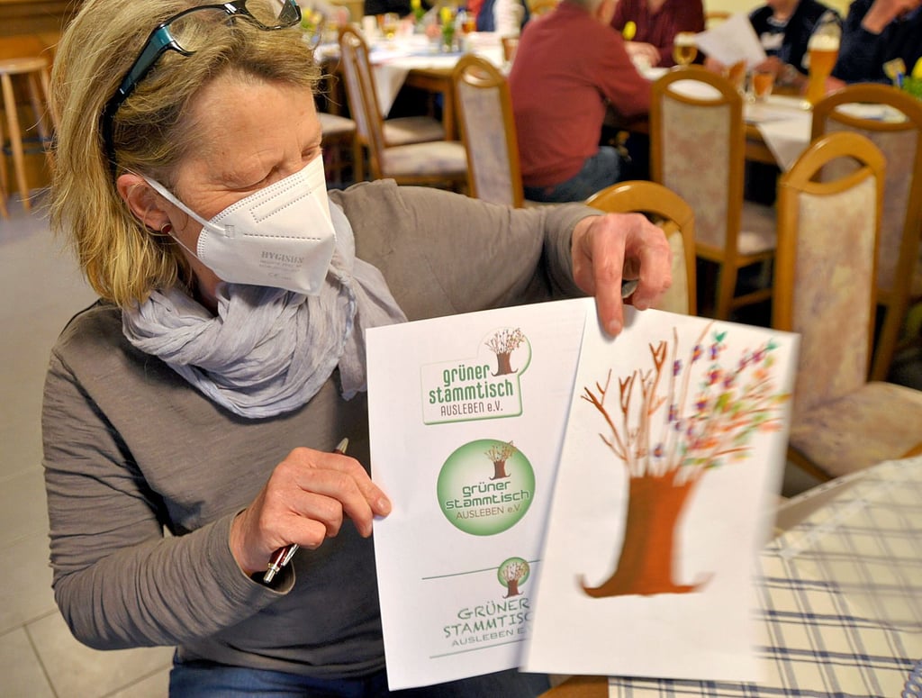Anne-Katrin Albrecht präsentiert die Entwürfe für das Vereinslogo. Der von ihrer Enkeltochter gezeichnete Baum war die Grundlage. Die Vereinsmitglieder sprachen sich für das mittlere Logo aus.