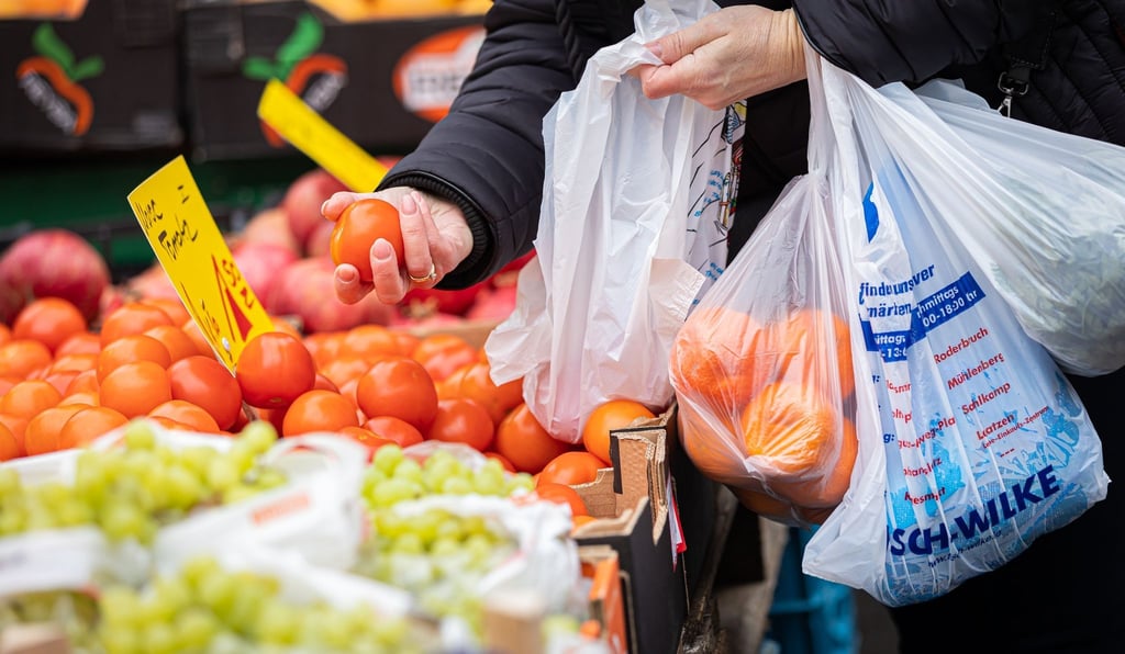 Eine Kundin begutachtet eine Tomate auf einem Wochenmarkt in Hannover. Wegen der steigenden Inflation müssen viele Menschen in Deutschland den Gürtel enger schnallen,