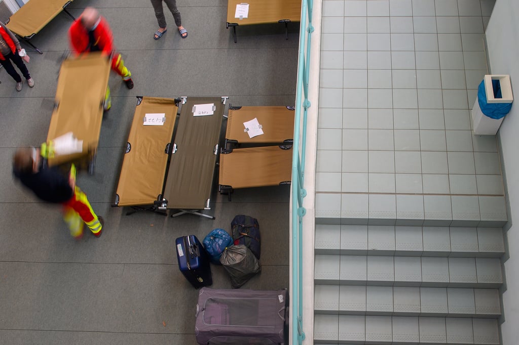 Helfer tragen Feldbetten in die Sporthalle Brandberge. Dort errichtet die Stadt Halle eine neue Notunterkunft für Flüchtlinge aus der Ukraine.