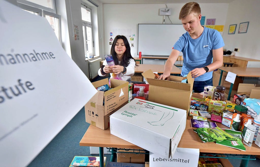 Josephine Le und Phillip Romanek verpacken im Heinrich-Heine-Gymnasium Spenden für vom Krieg betroffene Ukrainer.