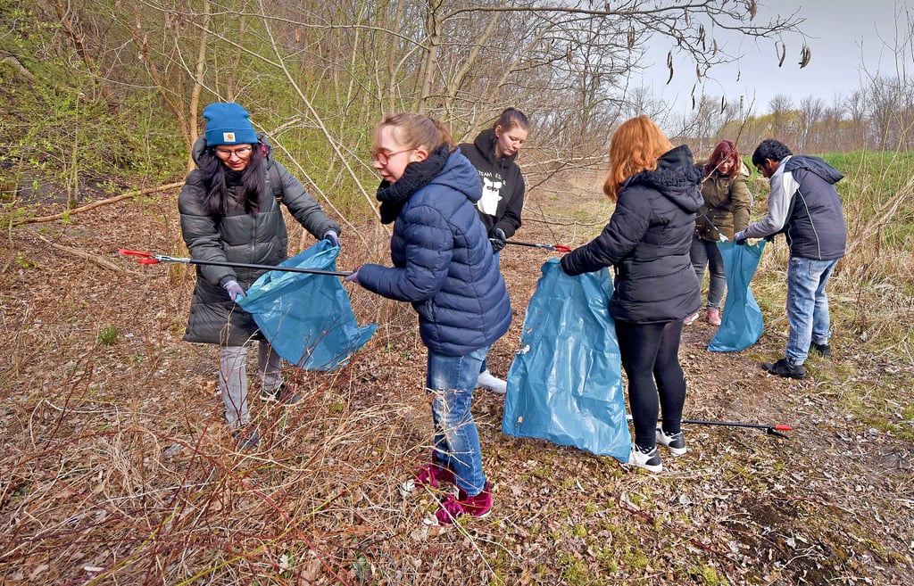 Alles, was im Wald und auf dem Parkplatz am Bitterfelder Bogen herumliegt, sammeln die Schülerinnen und Schüler mit den Lehrkräften ein.