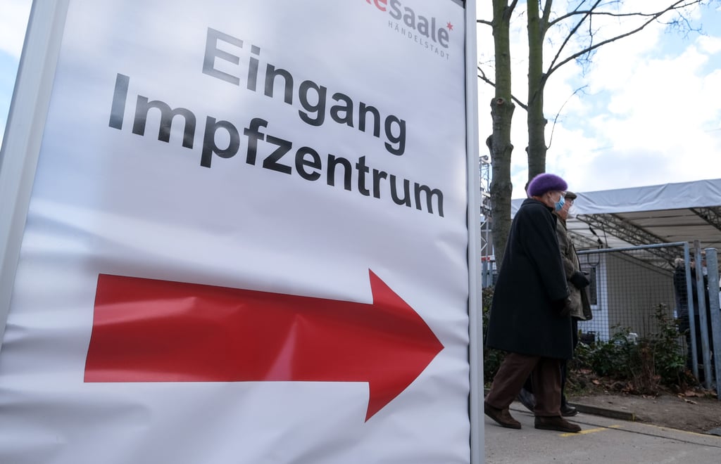 Blick auf ein Schild, das den Weg in das Impfzentrum in Halle weist.