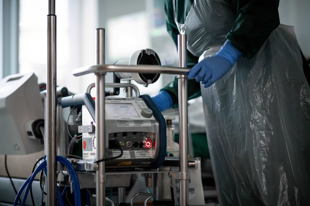 Eine Mitarbeiterin steht in einem Zimmer einer Corona-Intensivstation bedient ein Ecmo-Gerät (Symbolbild)