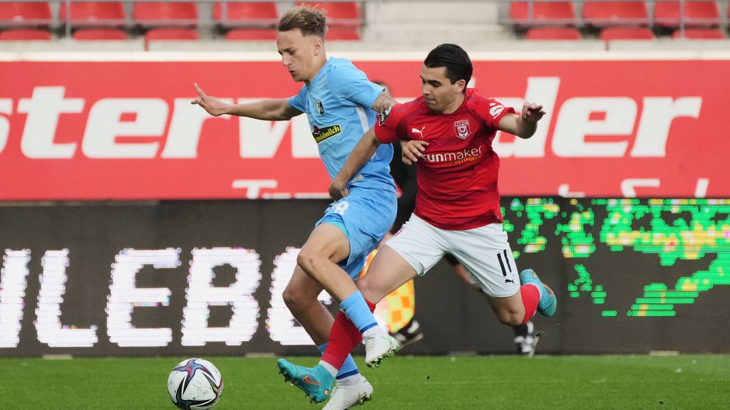 Freiburgs Sascha Risch klärt fair gegen Halles Jan Shcherbakovski.