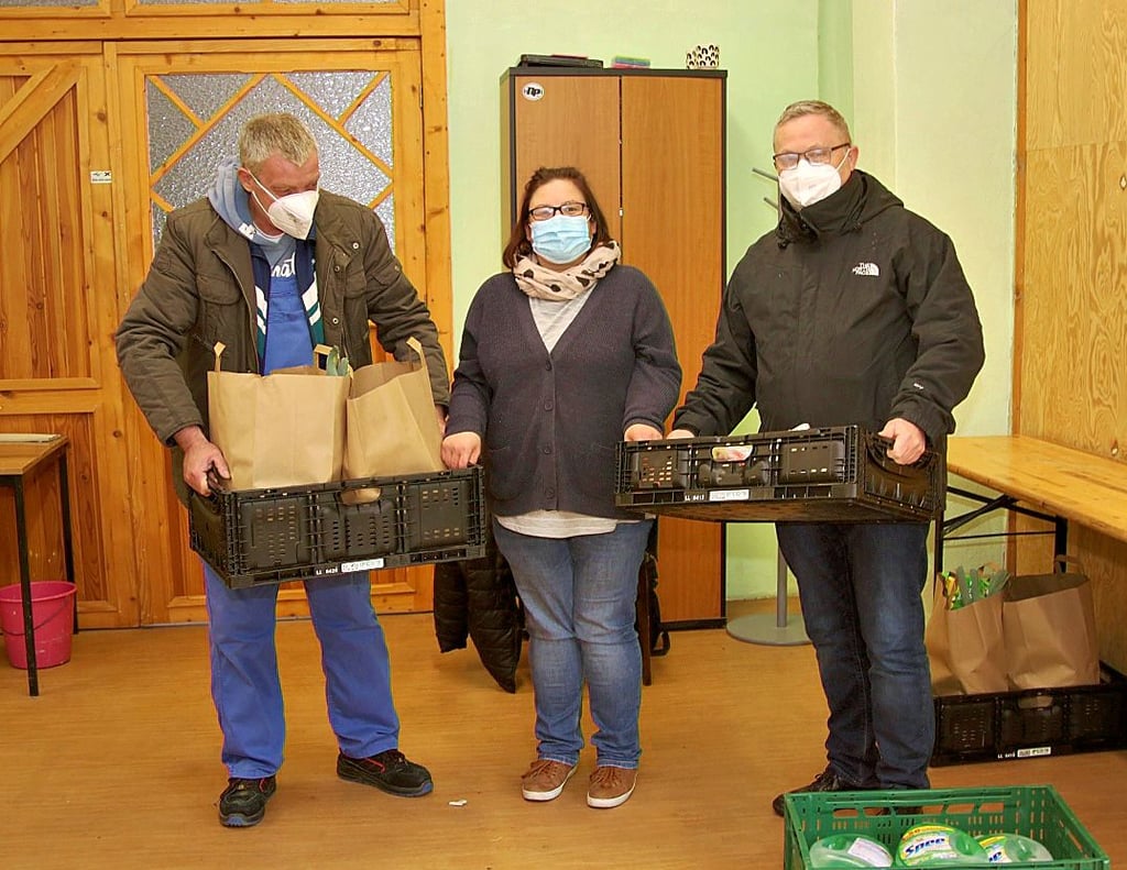 Thomas Röhrig und Yvonne Lange geben Möckerns Pfarrer Martin Vibrans (v. l.) Lebensmittel für Flüchtlinge, welche die Gemeinde betreut.