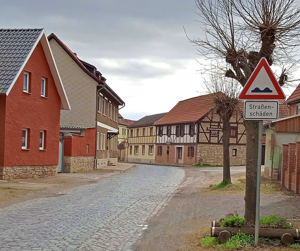 Ein Verkehrsschild weist auf den schlechten Zustand der Straße hin.