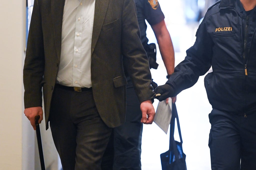 Der Angeklagte (v.l.) wird kurz vor Prozessauftakt Anfang Februar von Polizisten in das Landgericht Traunstein gebracht.