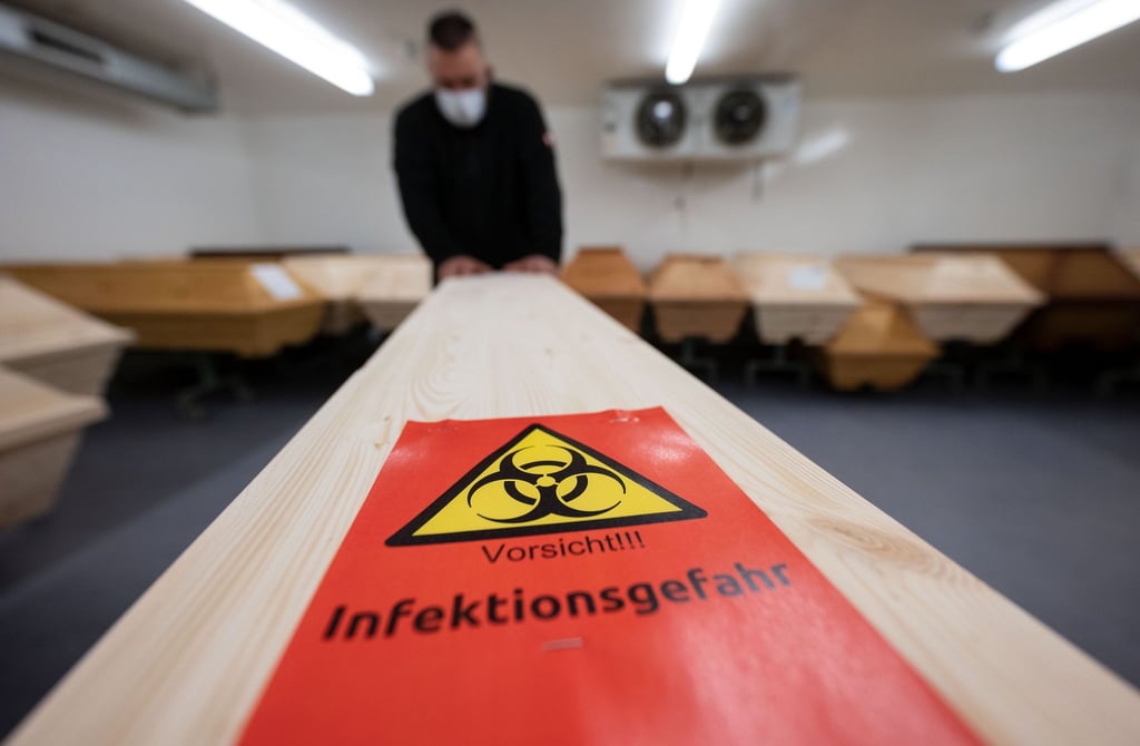 Ein Mitarbeiter eines Krematoriums mit einem Sarg eines Menschen, der mit Covid-19 verstorben ist.