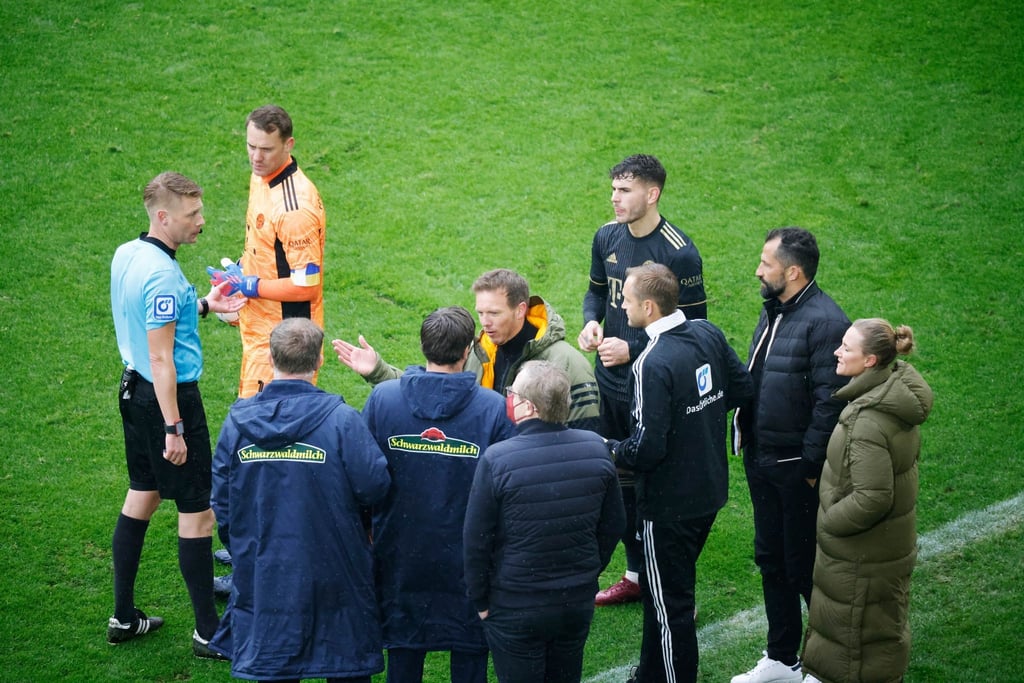 Spieler und Verantwortliche diskutieren mit Schiedsrichter Christian Dingert (l).
