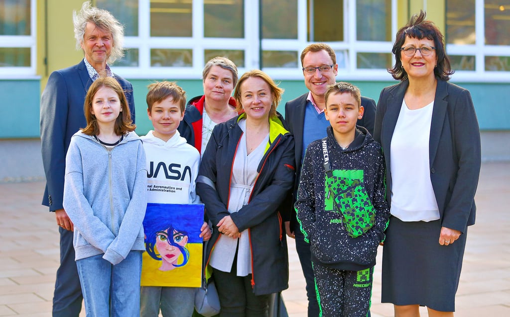 Landes-Bildungsministerin Eva Feußner (r.) ließ sich Freitag im Herder-Gymnasium Merseburg von Schulleiter Frank Werner-Bentke (l.) erklären, wie Kinder ukrainischer Geflüchteter unterrichtet werden. Sofia, Sascha und Kolja (v.l.) fühlen sich jedenfalls sehr wohl in ihren neuen Klassen. Auch Saschas Mama Olha Melnychenko (vorn Mitte) lobte die Integration, die durch viele Helfer möglich ist.