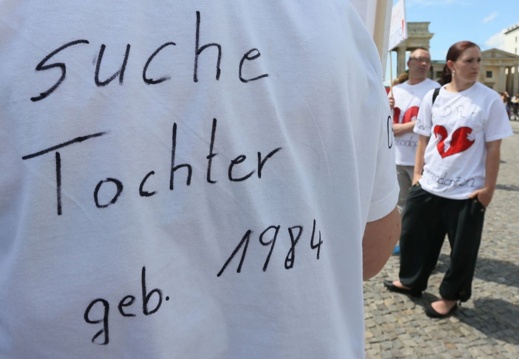 "Suche Tochter, geb. 1984" steht auf dem T-Shirt einer Frau bei einer Kundgebung.