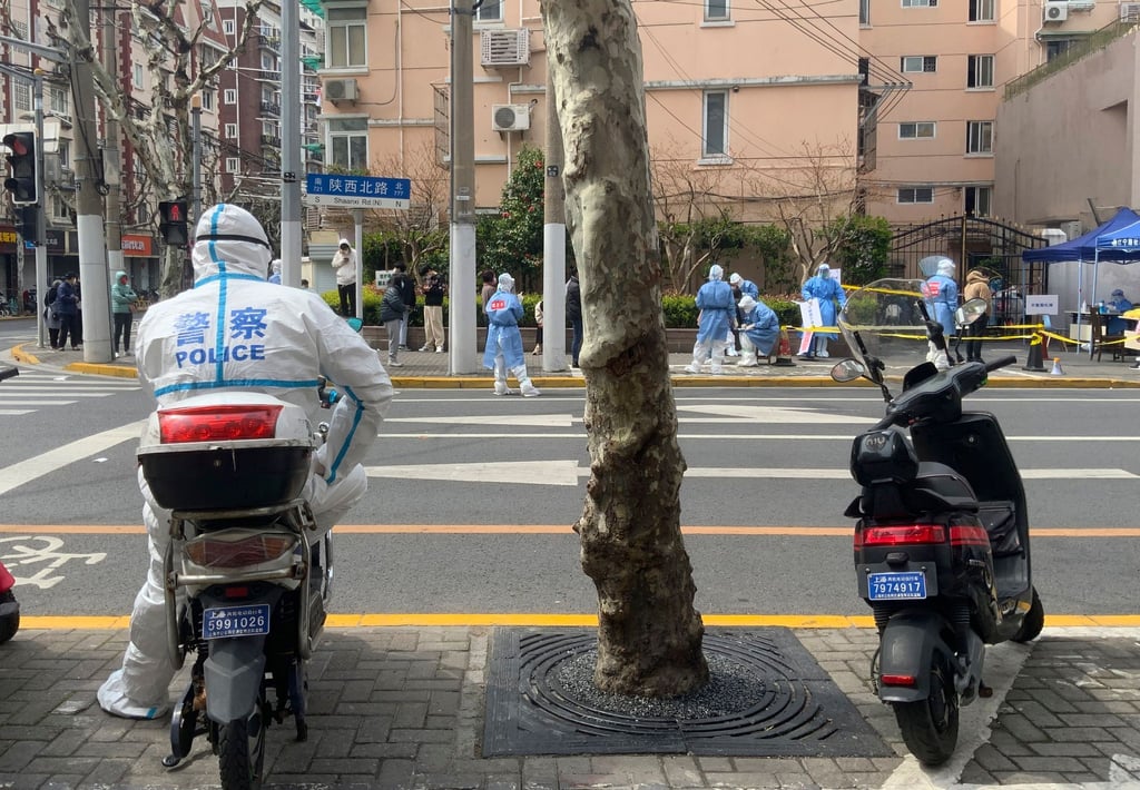 Ein Polizist in Schutzkleidung steht Wache im Jingan-Bezirk in Shanghai. Wegen der angespannten Corona-Lage ziehen die USA ihr Personal aus dem dortigen Konsulat ab.