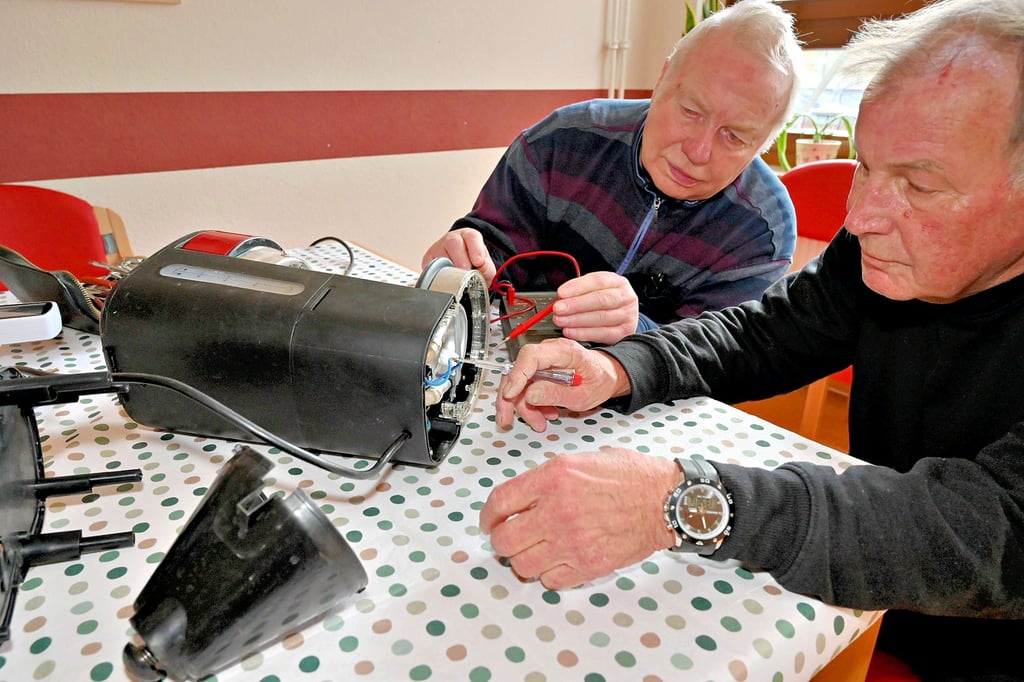Peter Frost und Friedhelm Boese tüfteln an einer defekten Kaffeemaschine im Repaircafé im Bürgerhaus Kannenstieg.