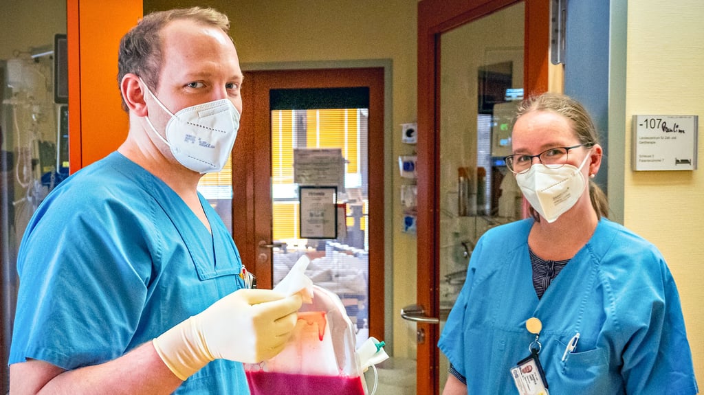 Assistenzarzt Frederik Ricken und Jessica Höll, kommissarische Klinikleiterin, mit dem Stammzellenbeutel auf dem Weg zu ihrer jungen Patientin.