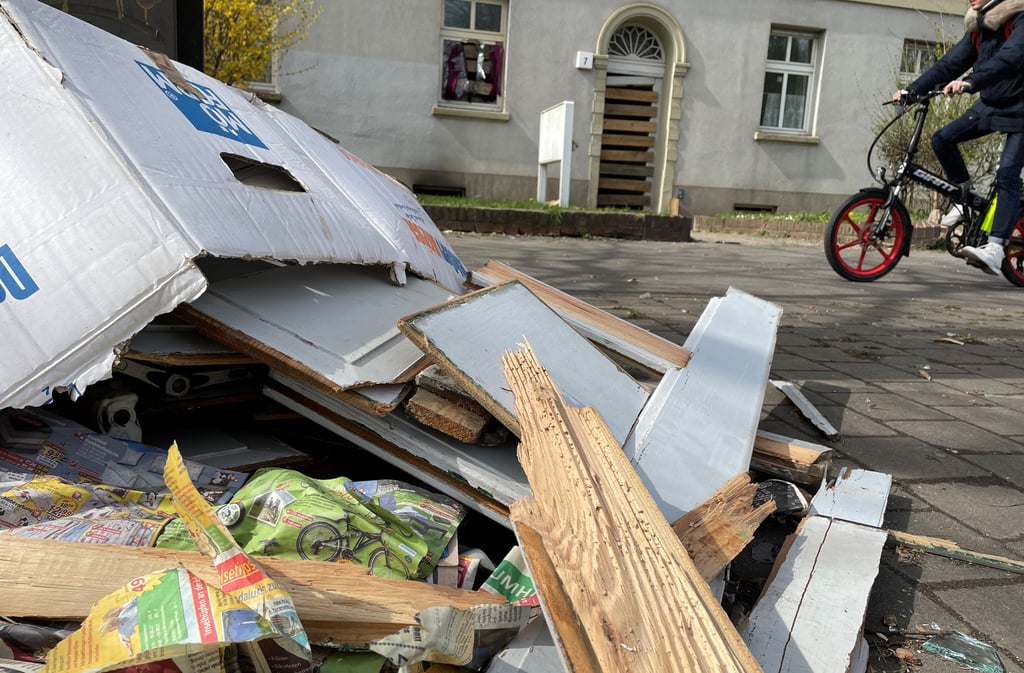 Trümmerreste liegen vor dem Haus in Magdeburg-Fermersleben, in dem es am Montag, 11. April 2022, eine Explosion gab. Die zwei betroffenen Hauseingänge wurden mit Brettern notgesichert.