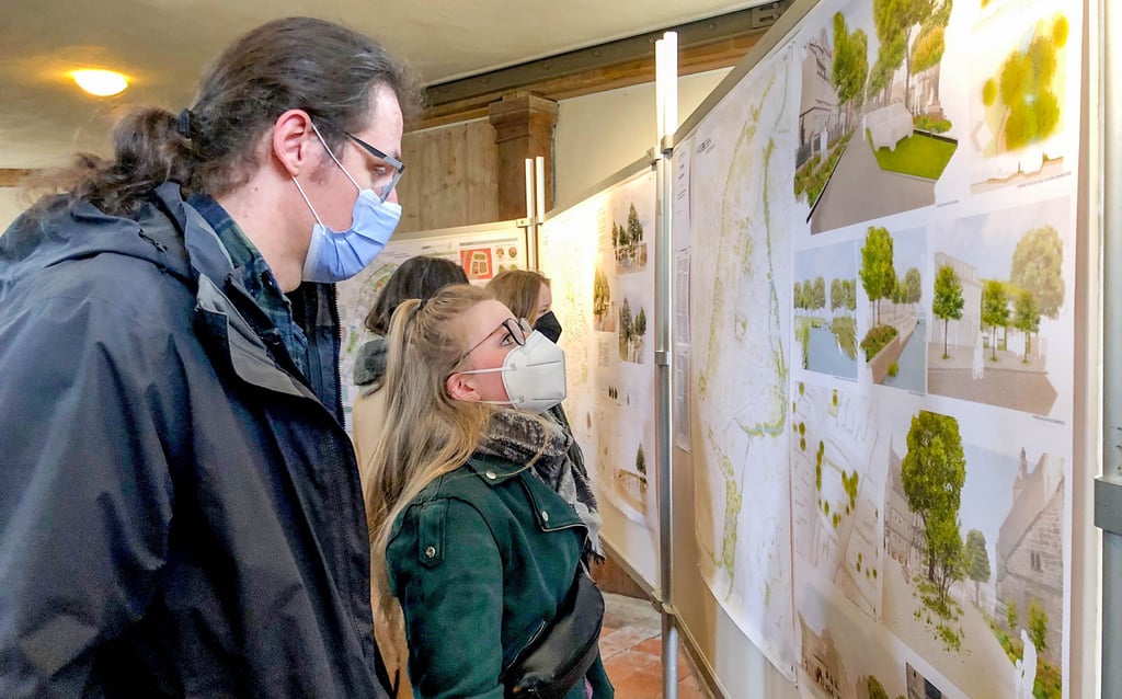 Besucher der Preisverleihungsveranstaltung schauen sich Arbeiten an, die beim Studentenwettbewerb eingereicht wurden und die jetzt in der Blasiikirche Quedlinburg präsentiert werden.