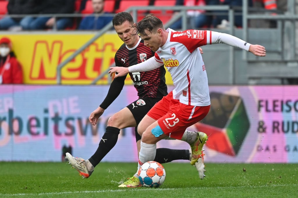 Regensburgs Steve Breitkreuz (r) versucht den Ball im Zweikampf vor Ingolstadts Florian Pick abzuschirmen.