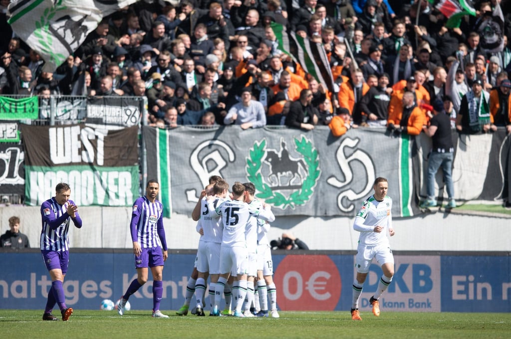 Die Spieler von Hannover 96 (r) jubeln im Erzgebirgsstadion vor ihren Fans nach dem Tor zum 1:0 gegen Aue.