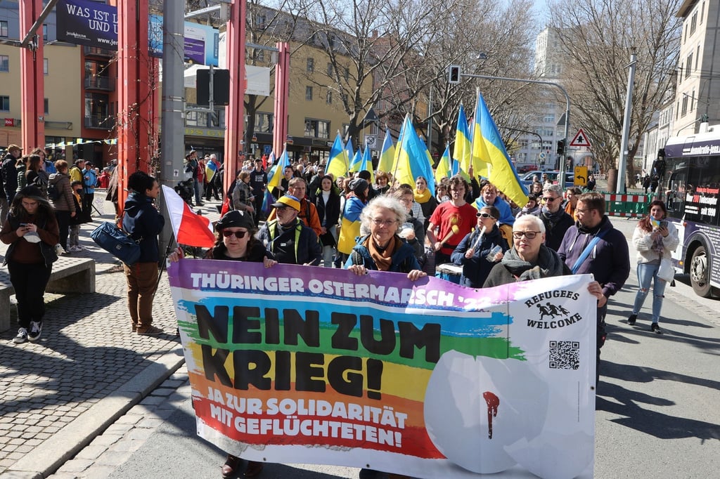 Teilnehmer eines Ostermarsches laufen in Jena nach einer Kundgebung auf dem Holzmarkt durch die Innenstadt.