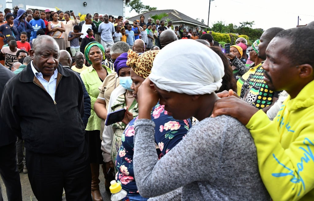Der südafrikanische Präsident Cyril Ramaphosa spricht in dem Ort Durban mit trauernden Familienmitgliedern.