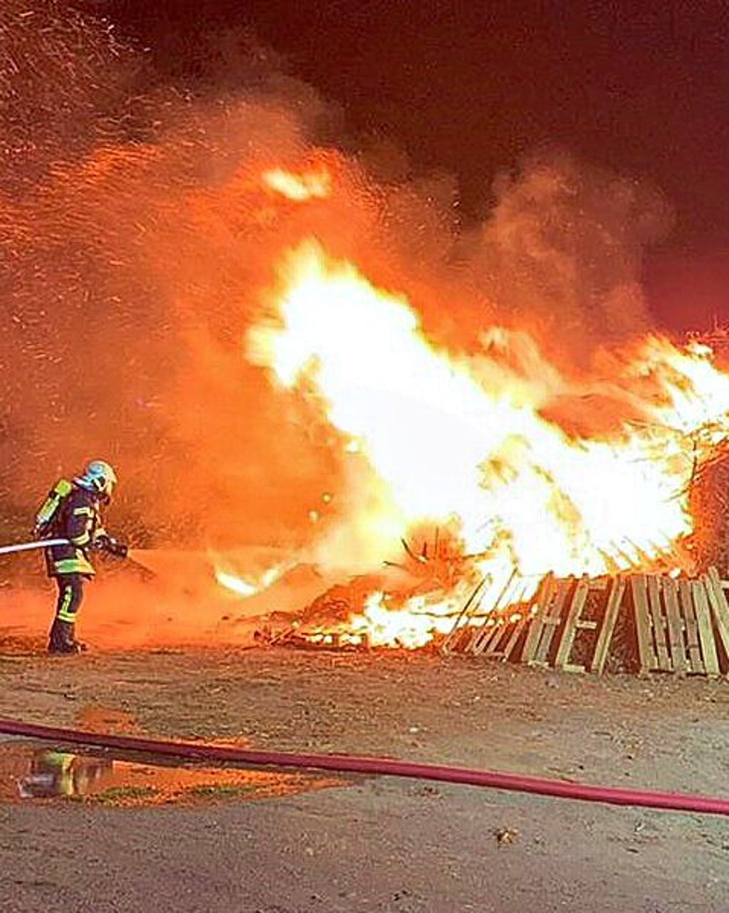 Die Feuerwehr beim Löschen des Osterfeuers.