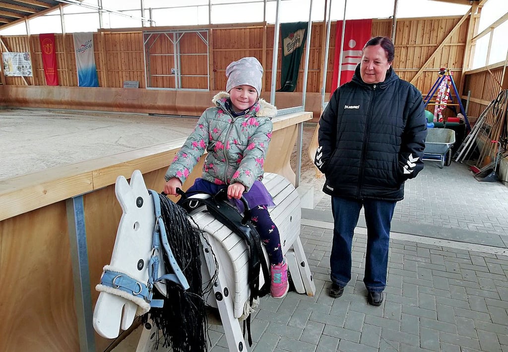 Nachwuchsarbeit wird auf der Reitanlage in Zeitz groß geschrieben, so darf Leni Stalive auf einem Holzpferd sitzen. Katrin Stalive schaut zu.