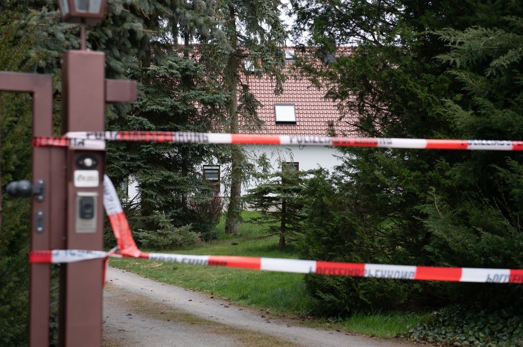 Ein Absperrband hängt an einer Einfahrt vor einem Wohnhaus. In dem Haus im Ortsteil Mittelbach wurden am späten Montagabend vier tote Menschen gefunden.