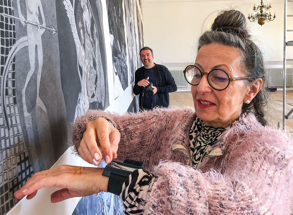 Der „Altar der Europa“ wird abgenommen. Vorsichtig entfernt Künstlerin Antoinette die Nadeln, die die Bilder festhalten, und legt sie auf ihr magnetisches Armband. Fotograf Lars Wiedemann dokumentiert den Abschied der Künstlerin von Merseburg.