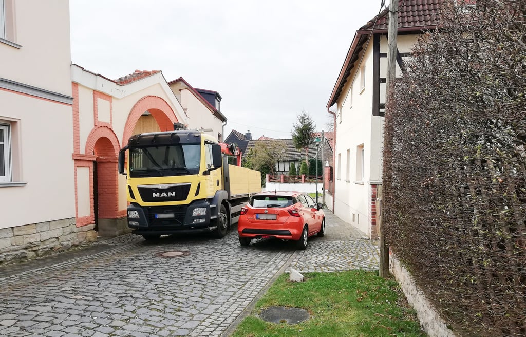 In der Kirchgasse von Predel ist es eng. Wenn Material geliefert wird, müssen Autos über den Fußweg ausweichen. Anwohner sind verärgert.