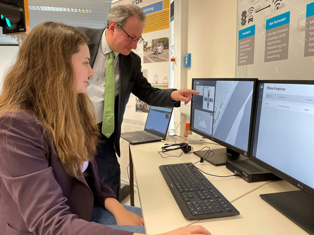 Prof. Hartmut Zadek, Leiter des Lehrstiuhls Logistik an der Otto-von-Guericke-Universität Magdeburg, und Projektleiterin Olga Biletska mit dem Prototyp einer Leitstelle zur Fernsteuerung von automatisierten Fahrzeugen.