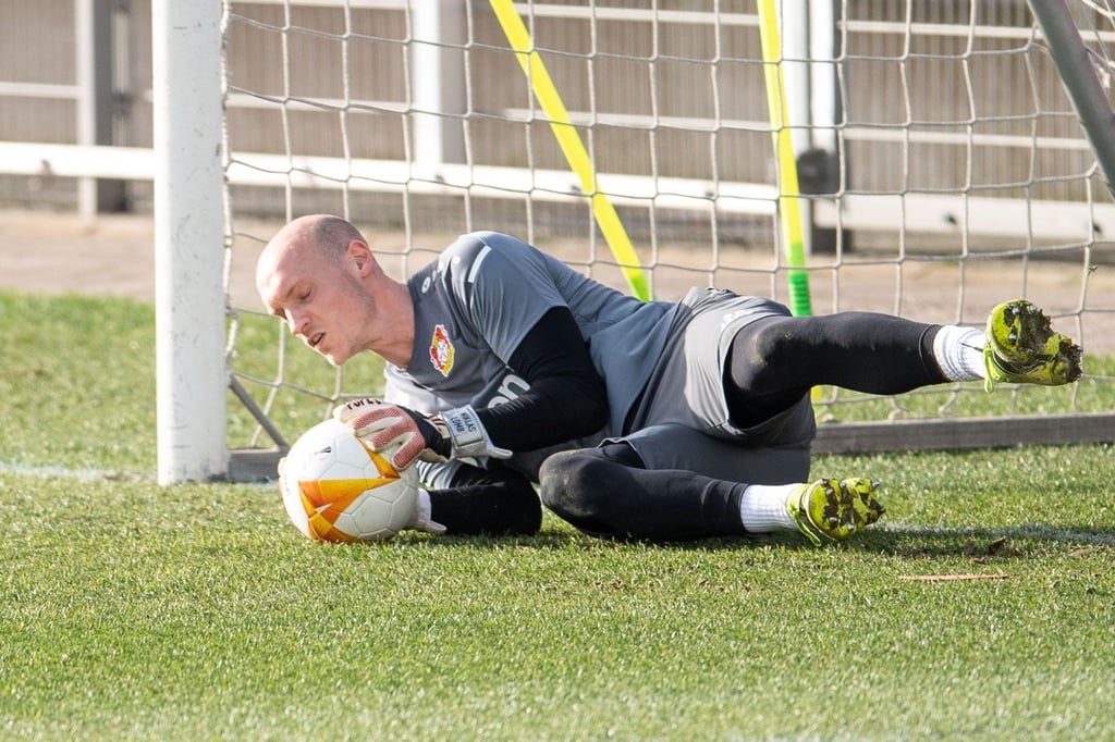 Leverkusens Torhüter Niklas Lomb fängt während des Trainings einen Ball.