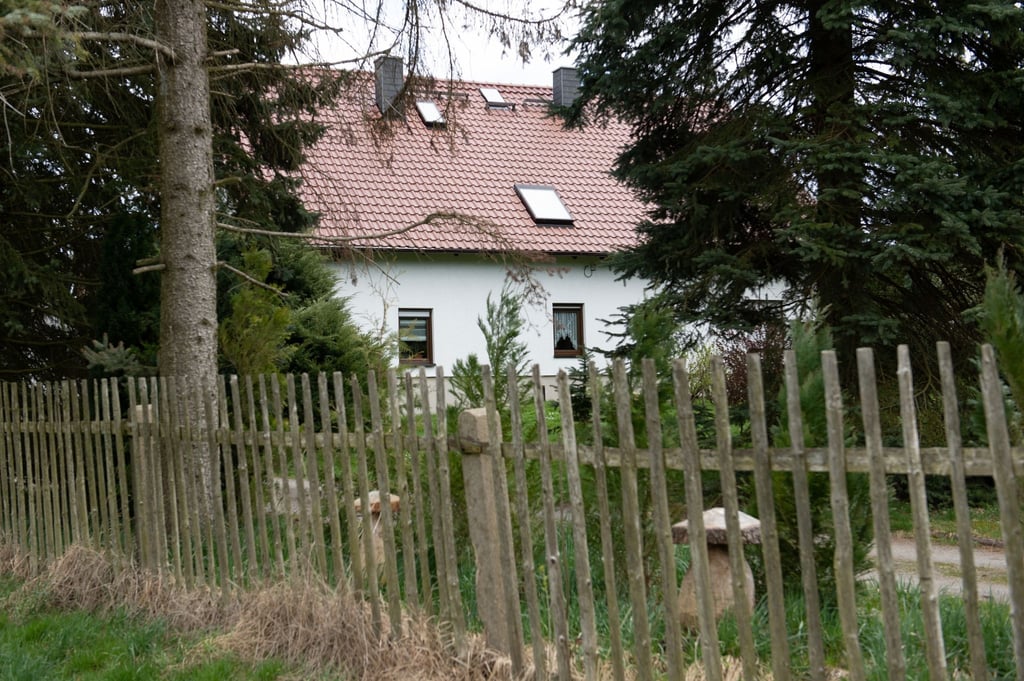 Ein Holzzaun umgibt das Wohnhaus, in dem vier Leichen gefunden worden sind.